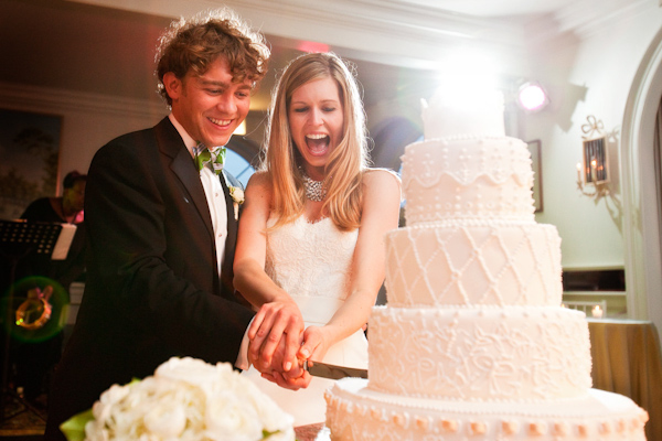 the happy couple cutting their five layer white wedding cake at the reception - photo by Washington DC based wedding photographers Holland Photo Arts
